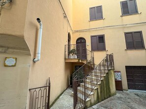 A narrow alleyway with a staircase leading to a second-floor balcony. - B&B StudioArcodia - Camera con Balcone (San Marco D`alunzio)