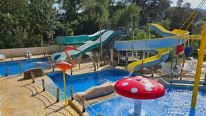 Ein Wasserpark mit mehreren Rutschen und einem zentralen Wasserspielplatz, der einen Pilz ähnelt.
