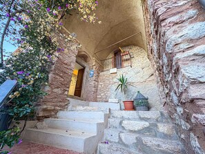 A stone staircase leading to a wooden door with a balcony above. - B&B StudioArcodia - Sant`Andrea (San Marco D`alunzio)
