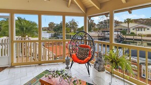 A spacious balcony with a view of a water body and surrounding greenery.