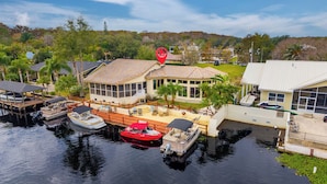 A waterfront property with a house, dock, and boats.