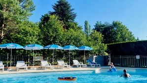 A swimming pool with lounge chairs and umbrellas, surrounded by trees. - Cozy chalet with terrace for 4 guests (Camon)