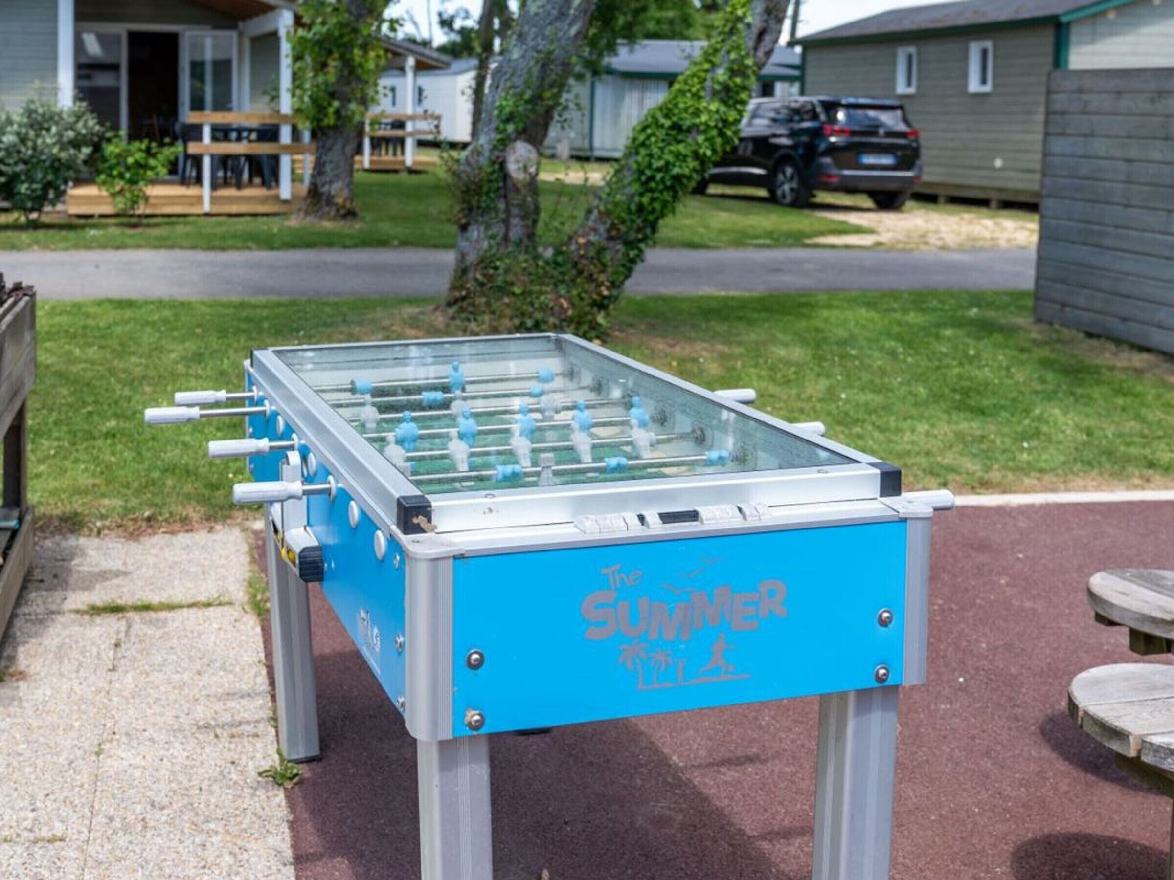 Un tavolo da calcio con base blu, posizionato all'aperto in una zona residenziale.