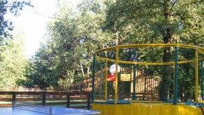 A ping pong table with blue legs, surrounded by a yellow and green play structure with a netted enclosure. - Mobile home with terrace, kitchen equipped for 4 guests (Neffes)