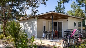 Een gelijkvloers huis met een overdekte veranda, een eethoek en fietsen die er buiten staan.