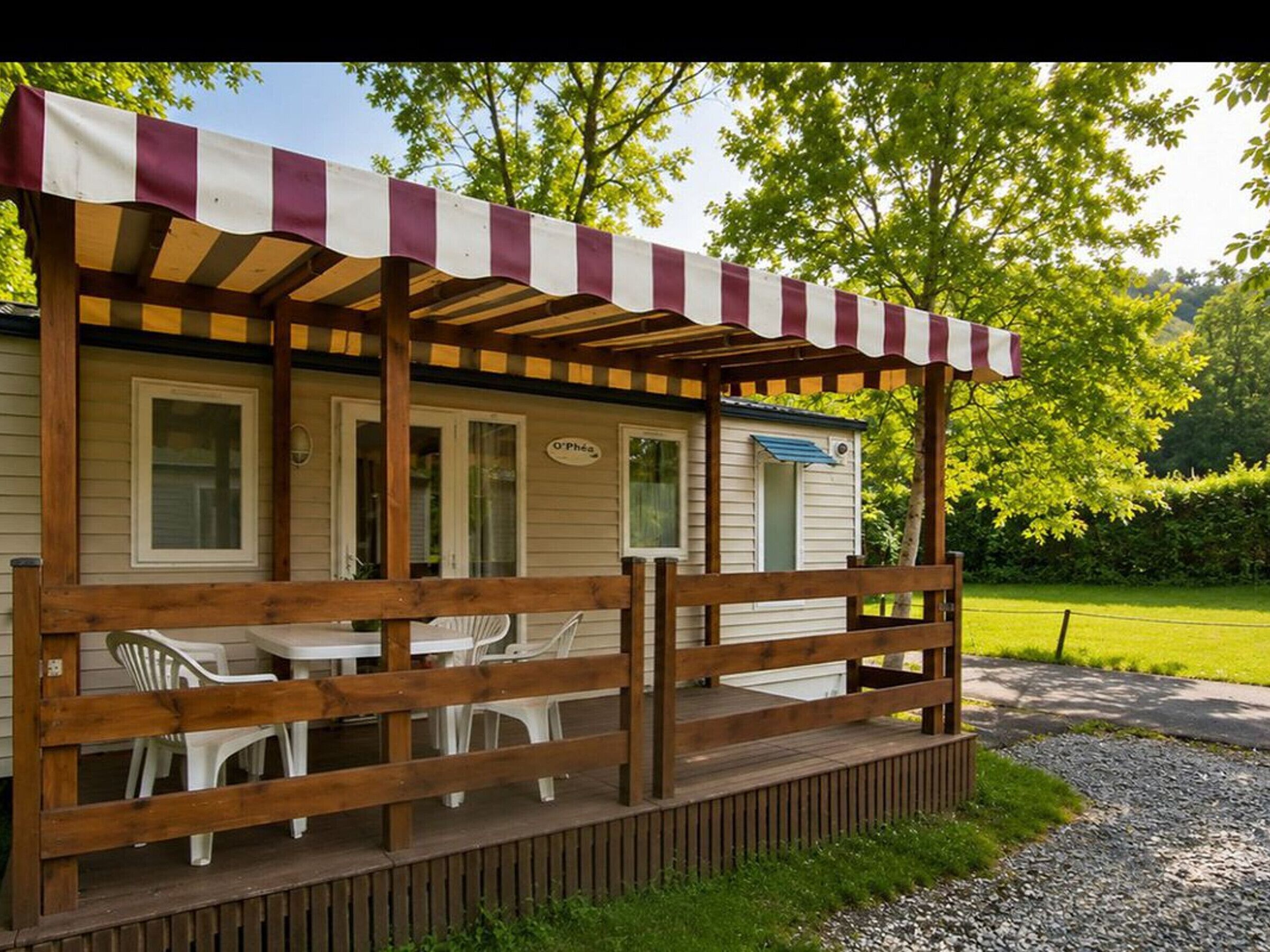 A mobile home with a wooden deck, outdoor seating, and a covered porch.