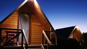 Eine Holzhütte mit einer Veranda und einer Treppe, die zum Eingang führt.