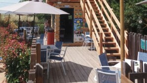 A wooden deck with outdoor seating, a staircase, and a covered area with umbrellas. - Cozy Mobile Home with Terrace in Roquebrune-sur-Argens (Roquebrune-sur-Argens)