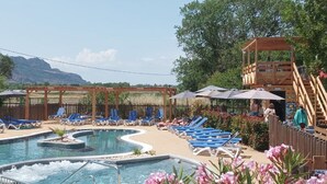 A pool area with lounge chairs, a hot tub, and a wooden pergola. - Cozy Mobile Home with Terrace in Roquebrune-sur-Argens (Roquebrune-sur-Argens)