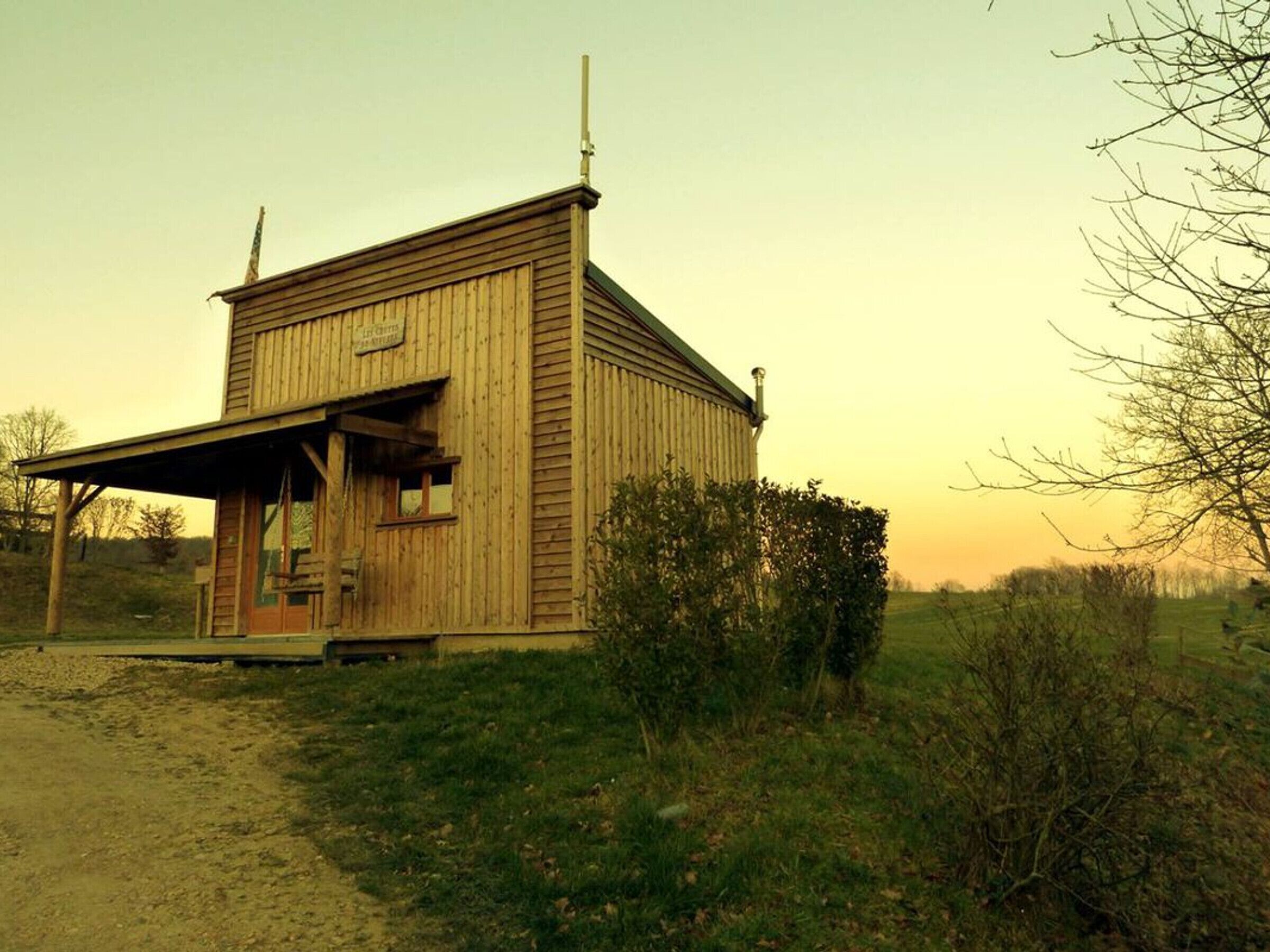 Ein rustikales Holzhaus mit Veranda, Schornstein und einem Schild, auf dem "The Old Mill" steht.