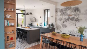 Une cuisine moderne avec un îlot central, des chaises noires et une table à manger.