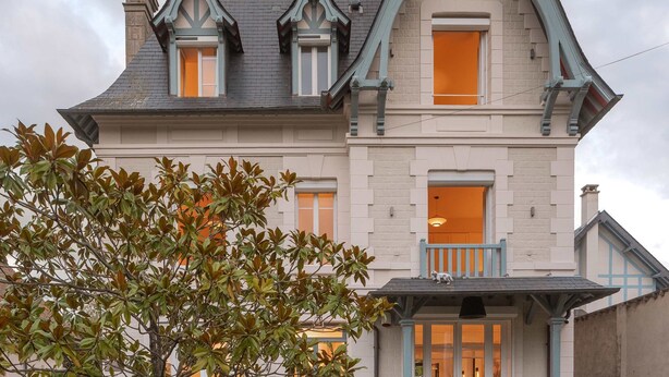Une maison de style victorien, dotée d’un toit à forte pente, de lucarnes et d’un porche en pierre.