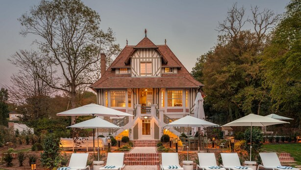 A large, two-story house with a prominent front entrance, a swimming pool, and outdoor seating with umbrellas. - Villa des Reves Luxury in Villers Pool Jacuzzi Padel Court Close to Deauville (Villers-sur-Mer)