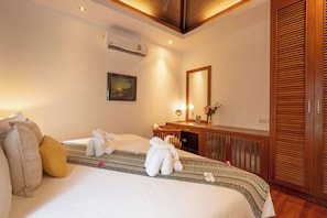A hotel room with a bed, a desk, a mirror, and a wardrobe. - Villa Amida • Balinese Pool Villa • Big Sala & Terrace • Nai Harn & Rawai Beach (Tambon Rawai)