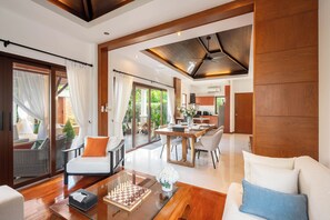 A spacious living area with a wooden coffee table, a chessboard, and a sofa with cushions. - Villa Amida • Balinese Pool Villa • Big Sala & Terrace • Nai Harn & Rawai Beach (Tambon Rawai)