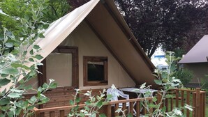Eine kleine Holzhütte mit einem Dreiecksdach, einer Holzterrasse und einem Fenster.