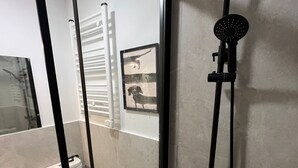 A modern bathroom with a glass partition, a toilet, a shower, and a small shelf with toiletries. - w Dreamy 1BR With Great Balconny (Madrid)