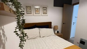 A neatly arranged bedroom with a bed, a bedside table, a lamp, and framed pictures on the wall. - w Dreamy 1BR With Great Balconny (Madrid)
