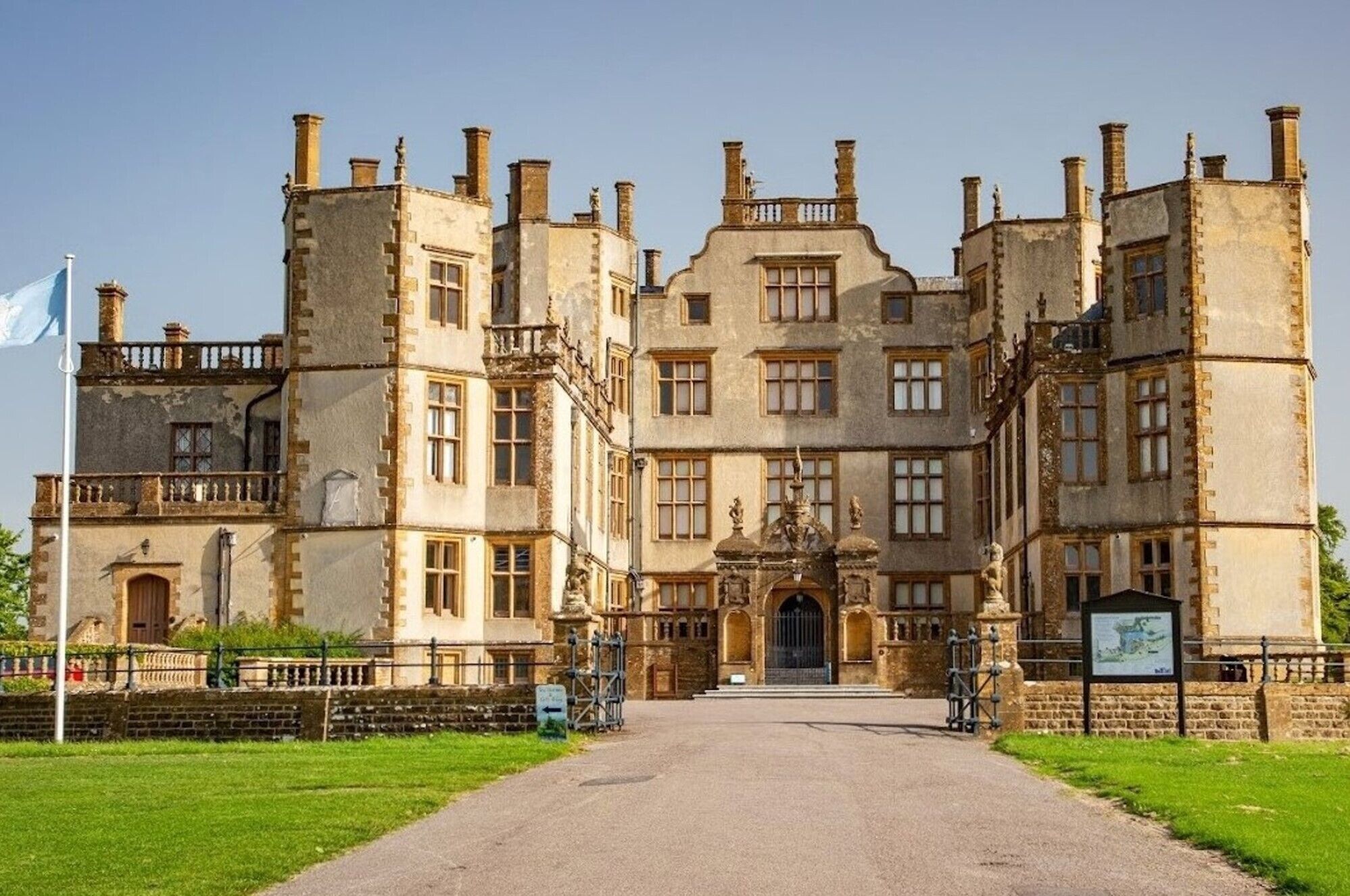 A historic building with a symmetrical facade, multiple chimneys, and a central entrance with a decorative archway.