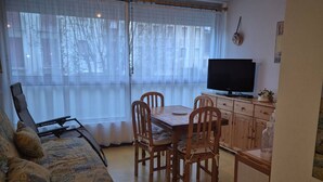 A cozy living room with a sofa, a dining table with chairs, a television, and a cabinet. - Charming T2bis 4-6 people, near center, Cauterets (Cauterets)