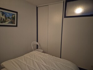 A bedroom with a bed, a white headboard, a framed picture on the wall, and a sliding door. - Charming T2bis 4-6 people, near center, Cauterets (Cauterets)