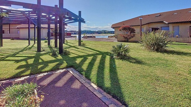 Ein Innenhof mit einer Pergola, einem Swimmingpool und einem Gebäude mit einem Ziegeldach.