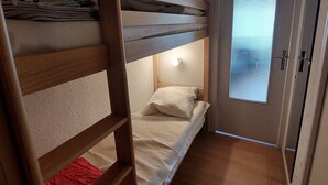 A bunk bed room with a ladder, a small bedside table, and a window with blinds. - 22m² Studio for 4 near slopes (Les Deux Alpes)