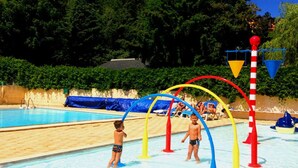 Une piscine avec des toboggans et une zone de sable.