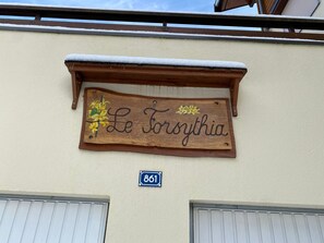 Ein Holzschild mit der Aufschrift 'Le Toroythia', angebracht an einem Gebäude, unter dem ein Schild mit der Nummer '861' angebracht ist.