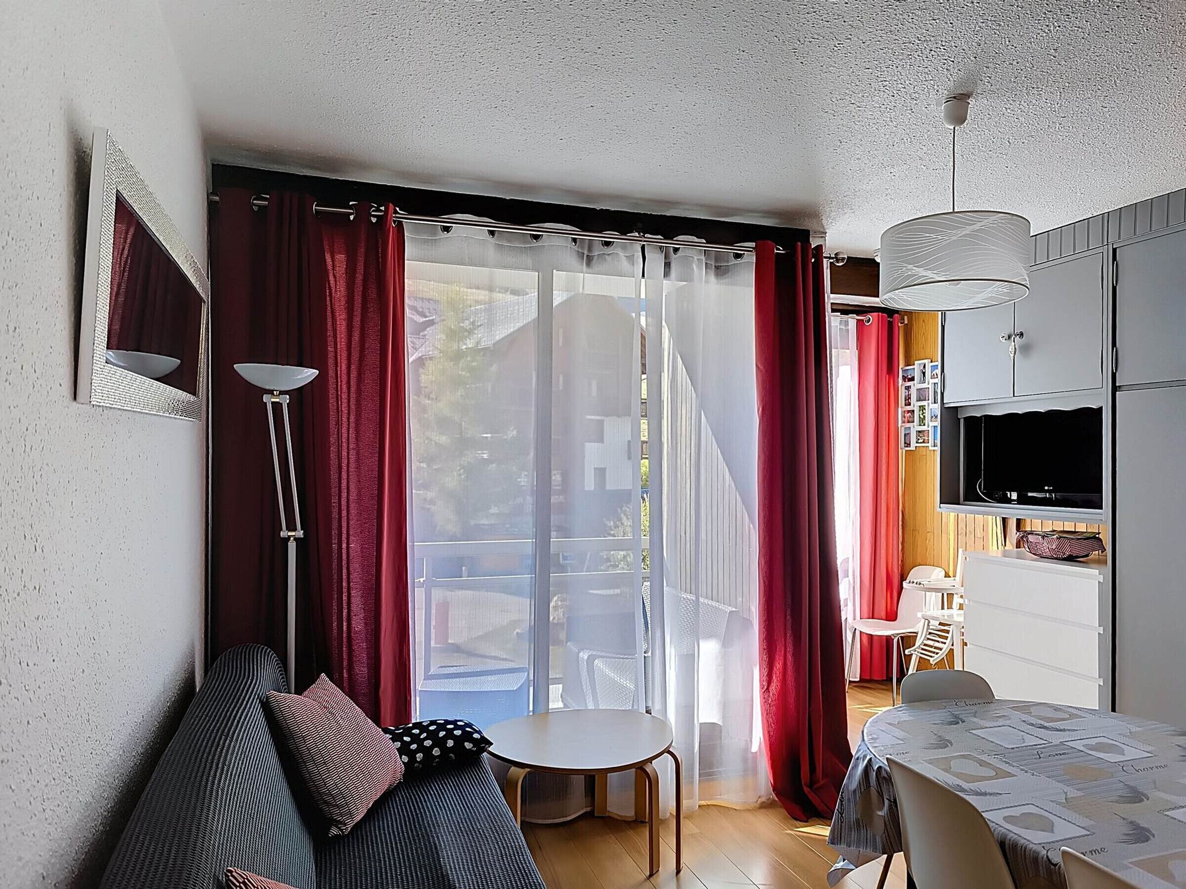 A compact living space with a sofa, a dining table, and a TV.