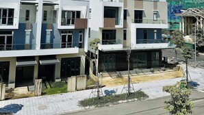 A modern residential building with multiple balconies, a paved walkway, and a construction site in the background. - Dreamy homestay Hue (Hue)