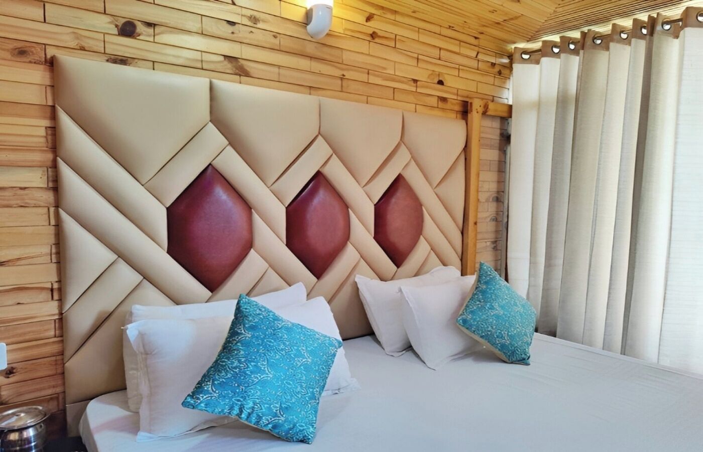 A bedroom with a wooden headboard, a bed with white linens, and decorative pillows.