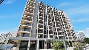 A modern high-rise building with multiple balconies, large windows, and a clean, contemporary design. - 1BR Creek Beach Access (Dubai)