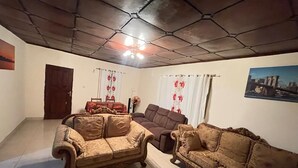 Un salon avec deux canapés, un ventilateur de plafond et une porte.
