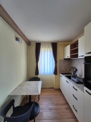 Apartamento conforto, 1 cama Queen, sacada, vista para a cidade | Cozinha privada