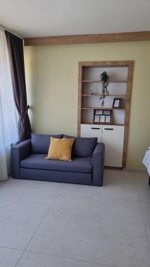 Apartamento conforto, 1 cama Queen e sofá-cama, sacada, vista para a cidade | Área de estar