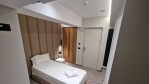 A modern hotel room with a bed, bedside tables, a wardrobe, and a door. - Tirana Room Rentals • Single Bed • Free Wi-Fi • Private Bathroom • TV (Tirana)
