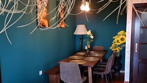 A dining area with a table, chairs, a lamp, and a vase of sunflowers. - Rural house 'Sombrerocordobe' with private pool, jacuzzi, and air conditioning (Cordoba)