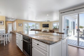 A kitchen with white cabinetry, a granite countertop, and a built-in oven.