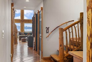 A wooden staircase leading to a lofted area with a view of the mountains.