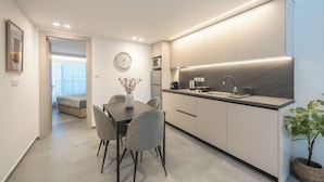 Una cocina moderna con comedor, un reloj en la pared y una planta.