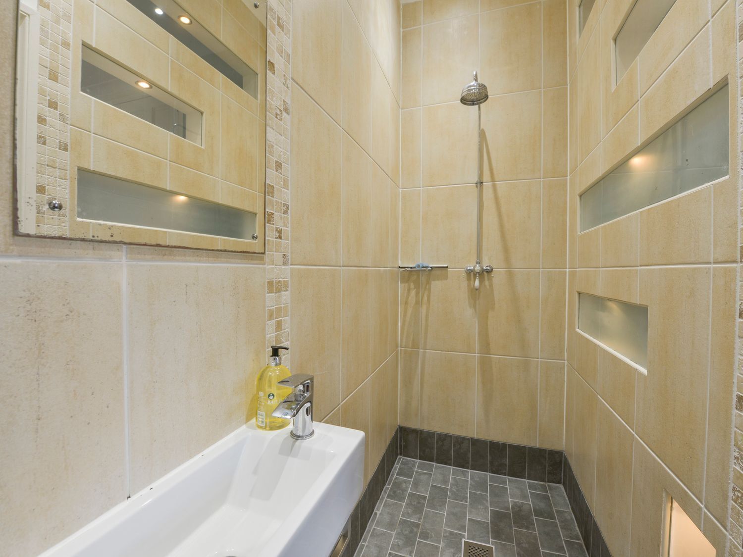 Un bagno con una vasca, una doccia e un dispenser di sapone.