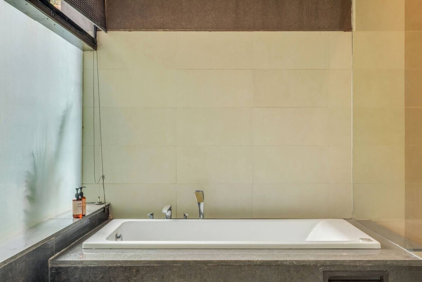 Une salle de bain avec une grande baignoire, un miroir et un porte-serviettes.