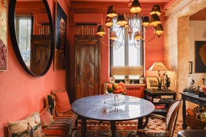 A room with a round table, a sofa, a chandelier, and a large mirror. - Guest Room “Echoppe 33 - Bègles, Bordeaux” with Private Terrace, Wi-Fi, and Air Conditioning (Bègles)