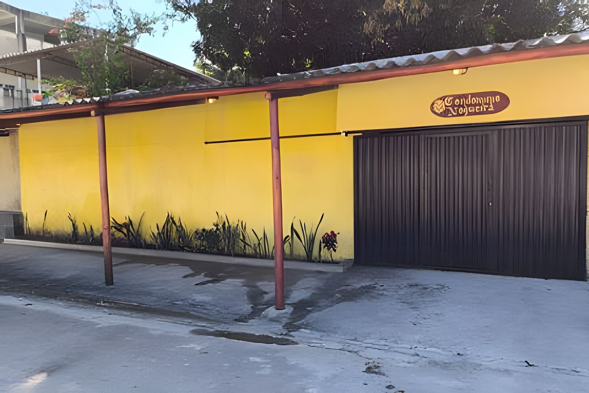 Um edifício amarelo com uma porta de garagem preta e uma placa que diz 'Condomínio Novo Horizonte'.