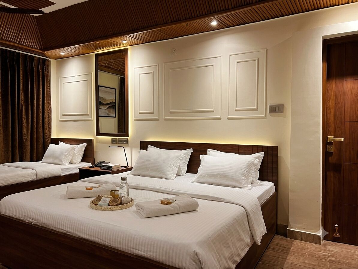 A hotel room with two beds, a wooden ceiling, a mirror, and a door.
