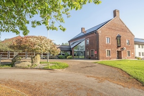 A brick building with a modern design, a glass entrance, and a stone pathway leading to it. - Jubilee First-floor Single Bedroom (Penrith)