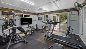 Une salle de sport équipée de tapis de course, d’appareils de musculation et d’un vélo d’appartement.