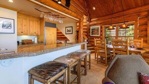 A log cabin interior with a kitchen, dining area, and bar. - Summit Cabin 3 Bedroom Home (Telluride)