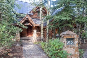 A log cabin with a stone entrance, surrounded by trees. - Summit Cabin 3 Bedroom Home (Telluride)